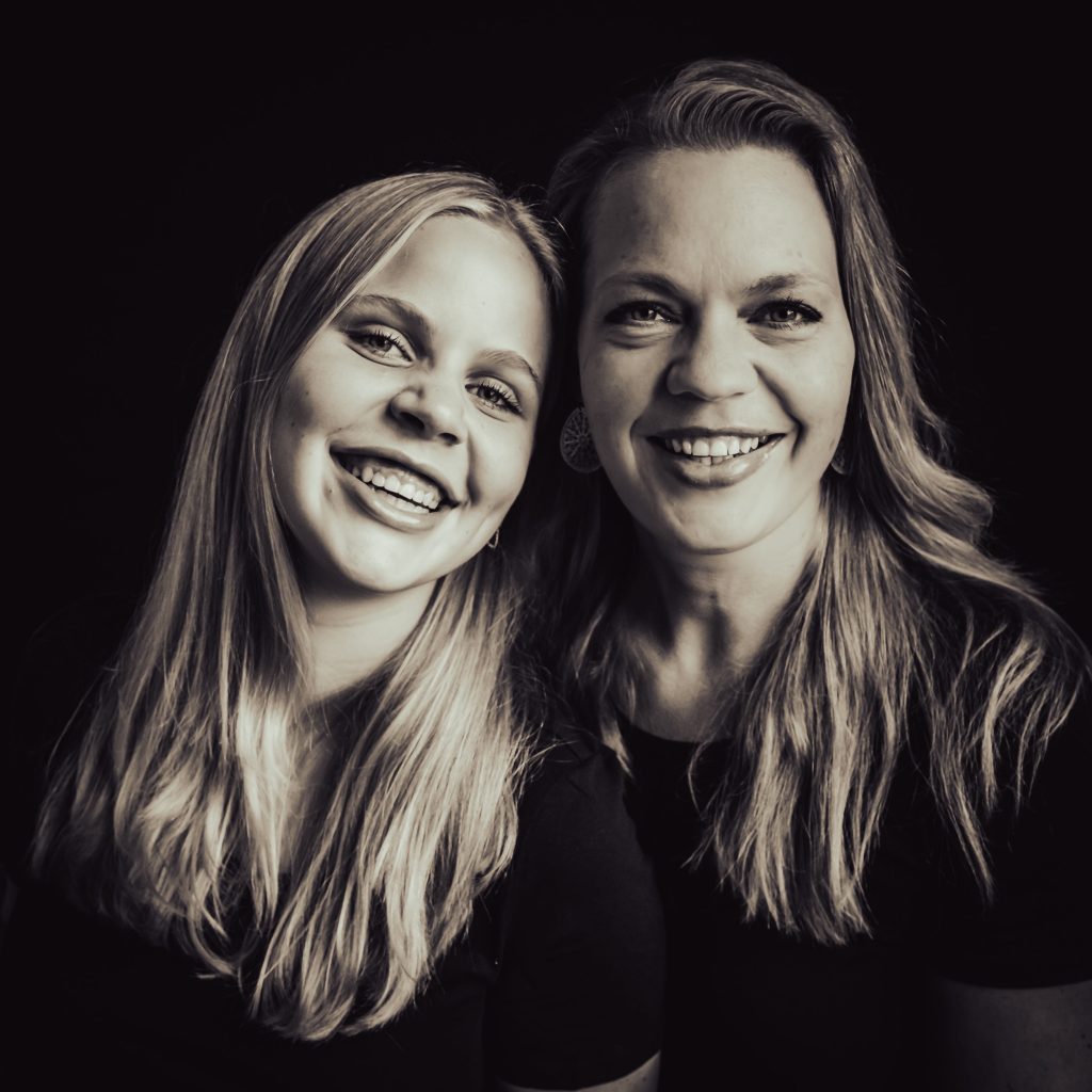 vrolijke zwart-wit portretfoto van moeder en dochter. foto is met een zwarte achtergrond